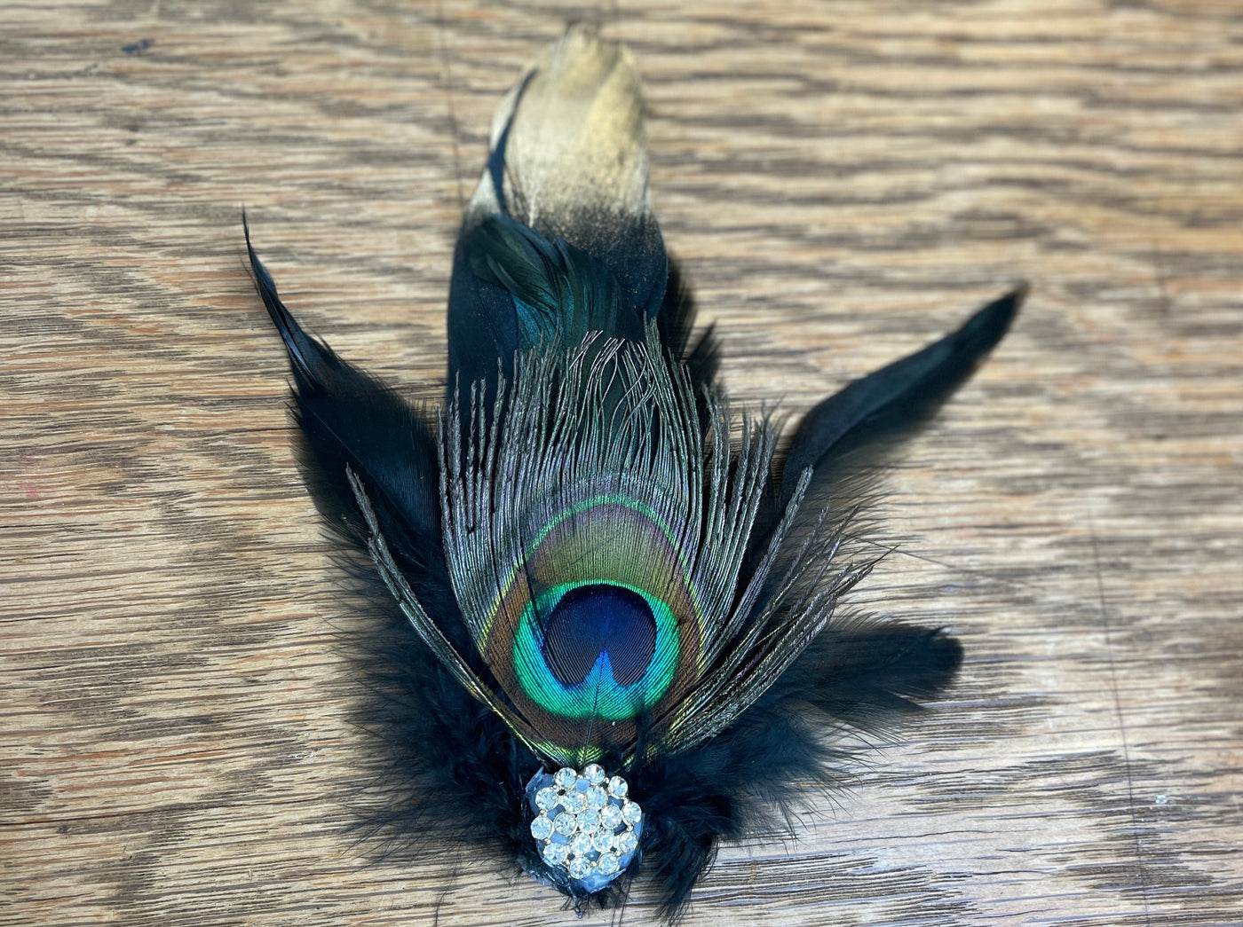 gold dipped crow feather with peacock feather and diamond broach